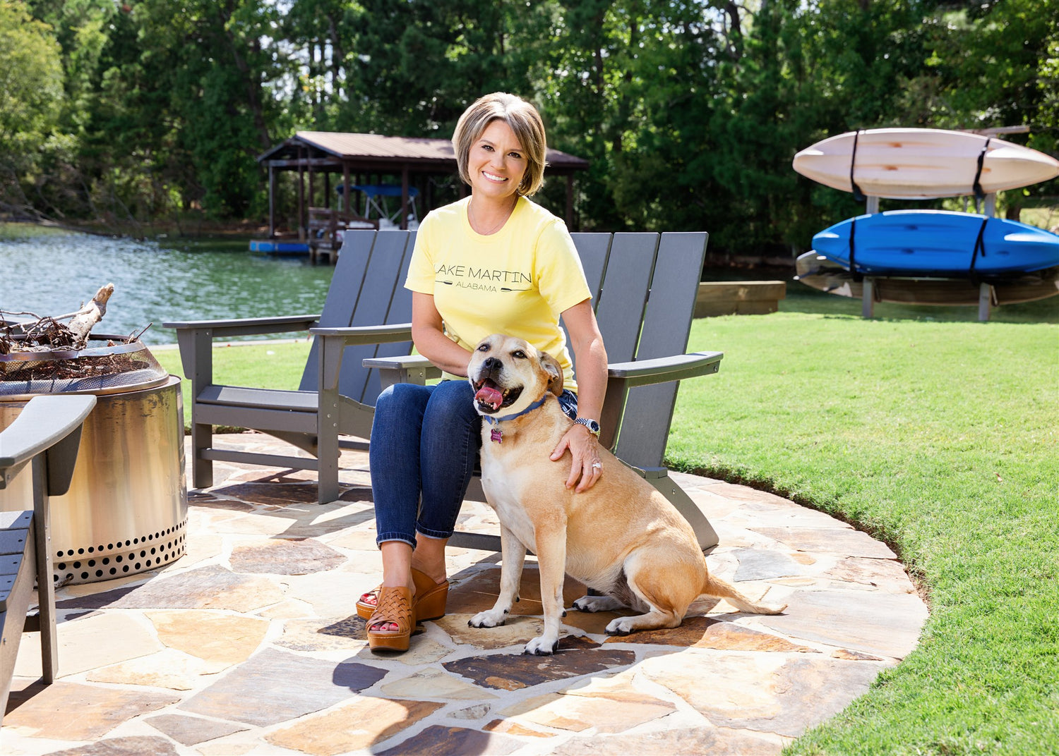 Tamela and her dog at the cottage, sitting near the fire pit